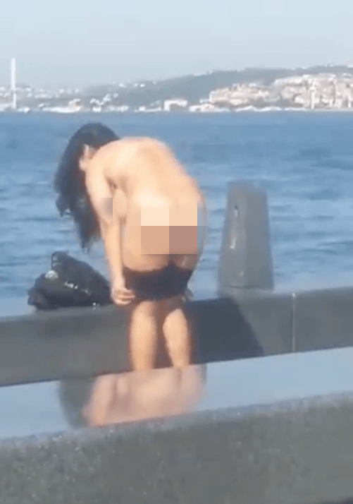 Kimseye aldırış etmeden soyunup denize atladı